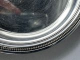 a silver plate with a picture of a man in a mirror