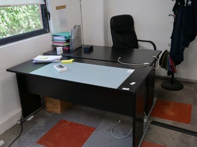 un bureau noir avec un plateau en verre et une chaise noire