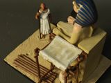 a figurine of an egyptian woman reading a book