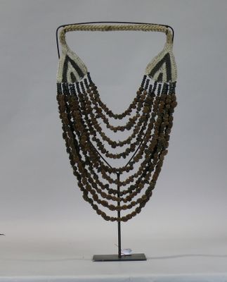 beaded necklace on a stand on a white background