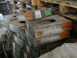 Plusieurs caisses de carottes sont empilées sur des palettes dans un entrepôt