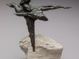 statue d'une femme assise sur un rocher, tenant un oiseau dans la main