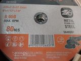 a close up of a metal grinding disc in a cardboard box