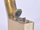 a small box that has a brass object inside of it