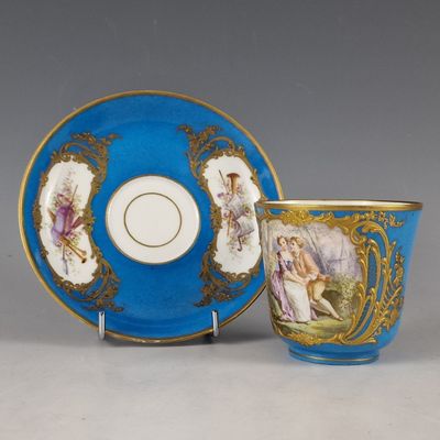 une image représentant une tasse et une soucoupe bleues posées à côté d'une assiette