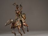 bronze statue of a man riding a horse with a bird on his back