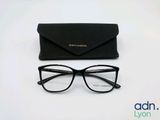 des lunettes noires et un étui noir posés sur une surface blanche