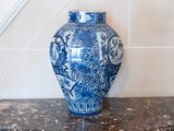 a blue and white vase sitting on a marble counter