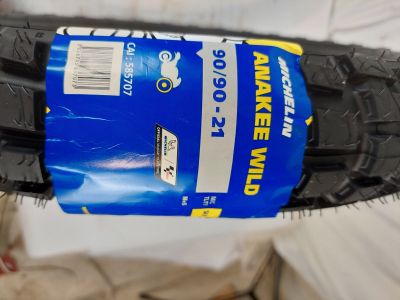 quelqu'un tient un pneu sur lequel est collé un autocollant