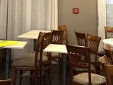 de nombreuses tables et chaises dans un restaurant, recouvertes de nappes blanches
