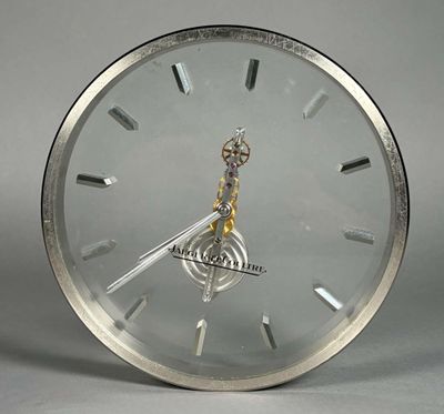 une horloge posée sur une table, avec une autre horloge au milieu de celle-ci