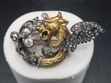 an image of a gold and silver broochle with wings