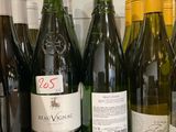 Des bouteilles de vin sont alignées sur un plan de travail dans une cuisine
