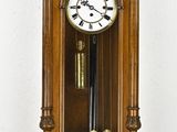 une horloge en bois accrochée au mur, sur laquelle figure un cadran