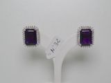 une paire de boucles d'oreilles en améthorate et diamants, présentée sur un socle blanc