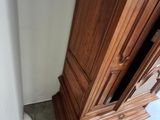 a tall wooden cabinet in the corner of a room