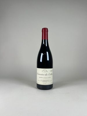 une bouteille de vin rouge posée sur une table blanche