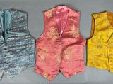 trois gilets alignés sur une table