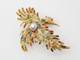 une broche en or ornée d'une perle au centre