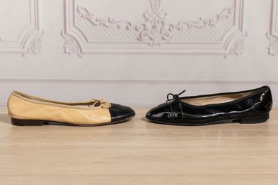 two pairs of black and beige shoes sitting on a wooden floor
