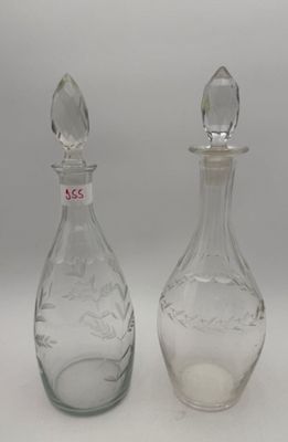 pair of clear glass decanters on white surface with white background