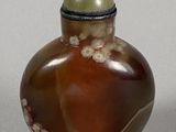 a small glass bottle with a green ball on it