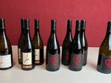 six bouteilles de vin sont alignées sur une table