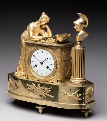 une horloge en or surmontée d'une statue
