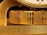 a gold clock with roman numerals on top of it