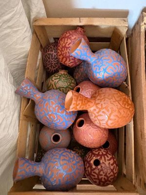 une boîte remplie de vases colorés posée sur une table
