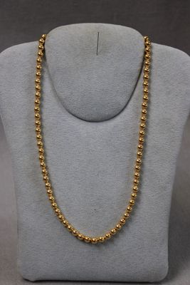 un collier de perles dorées sur un mannequin