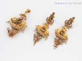 three pieces of gold and diamond jewelry on a white surface