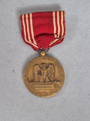 une vieille médaille entourée d'un ruban rouge et blanc