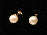 une paire de boucles d'oreilles en perles posées sur un fond de velours noir