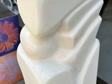 a white sculpture on the sidewalk in front of a store
