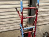 un diable rouge et bleu garé à côté d'une porte de garage