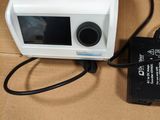 un petit appareil blanc branché à un chargeur