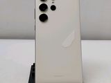 the back of a white phone with four black buttons on top of it
