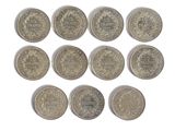 six different british coins are arranged in a row on a white surface
