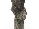 un buste antique en bronze représentant une femme, posé sur un socle en marbre