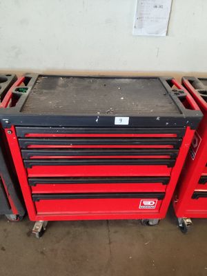 Trois caisses à outils rouges sont empilées les unes sur les autres dans un garage