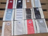 a lot of different colored shirts on a wooden table