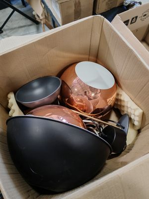 une boîte remplie de casseroles et de poêles posée par terre
