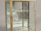 a glass display case with a gold leaf design on it