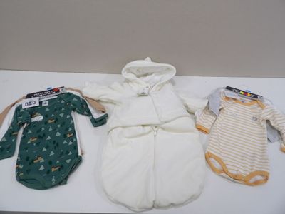 trois vêtements de bébé posés sur une table blanche