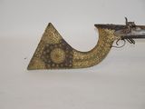 an old gun is sitting on top of a white surface