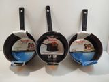 three frying pans sitting on top of a white counter top