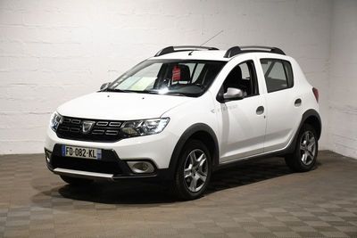 La Dacia blanche est garée dans une pièce blanche au sol carrelé
