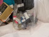 a plastic bag full of items that are on a bed