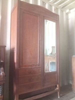 une armoire en bois surmontée d'un miroir, dans une pièce